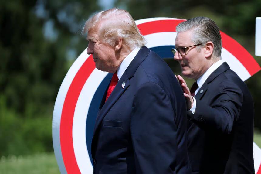 Former U.S. President Donald Trump standing outdoors with British Prime Minister Keir Starmer behind him, during a formal event with a red, white, and blue circular backdrop.
